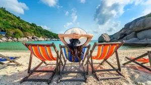 005521600_1688358365-woman-with-hat-sitting-chairs-beach-beautiful-tropical-beach-woman-relaxing-tropical-beach-koh-nangyuan-island